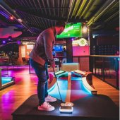 A man plays high-tech, indoor mini-golf at Putter Up, a new entertainment option in Pelham.