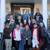 The America 250 Pelham committee poses for a photo on the City Hall front porch steps.
