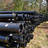 Image shows water pipes ready for installation along County Highway 11.