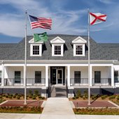 A white building with columns and flags out front. Pelham City Hall.
