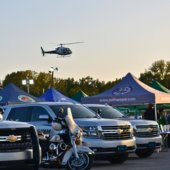 Pelham Police Department vehicles at National Night Out. A helicopter hovers overhead.