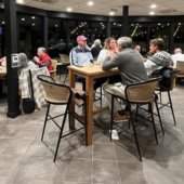 Men and women gather for dinner in the Fireside Room at Ballantrae Golf Course.