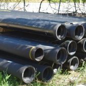 Ductile iron water main pipes are stacked and awaiting installation.