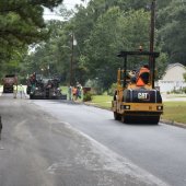 Workers using heavy equipment resurface a neighborhood street in Pelham.