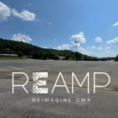 A photo of the cleared Oak Mountain Amphitheatre sige with the ReAmp logo over it.