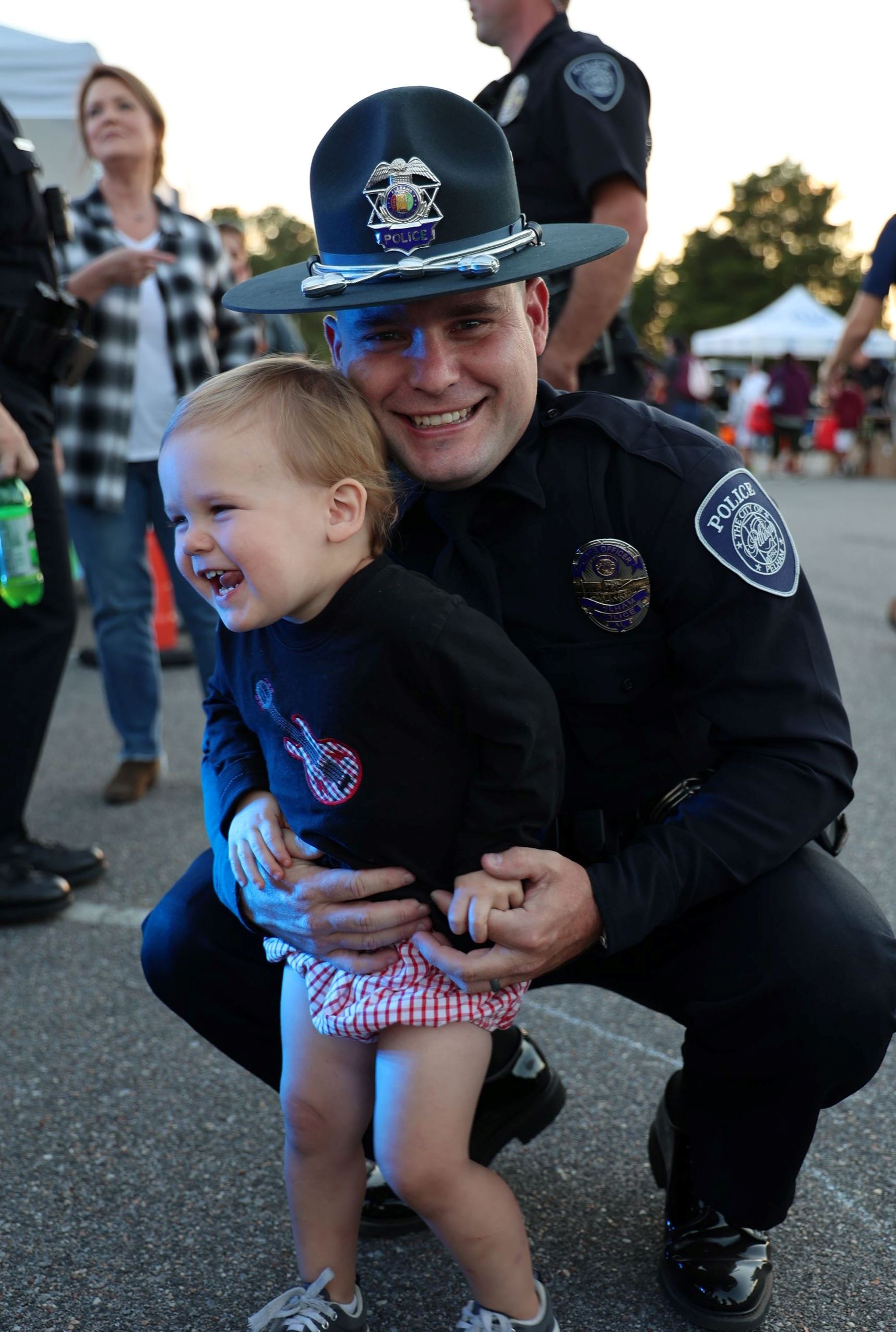 Police officer hugging his child at National Night out